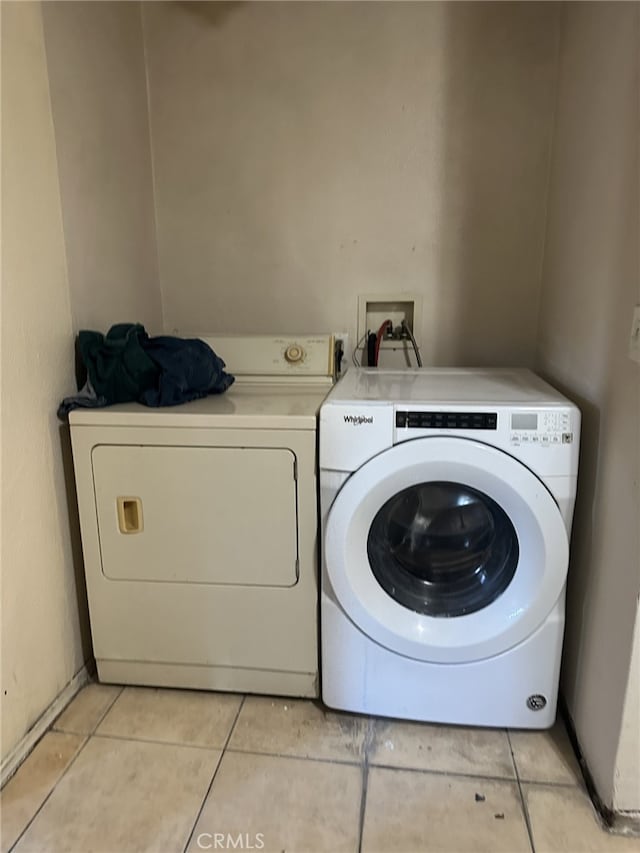 laundry room with separate washer and dryer and light tile patterned flooring