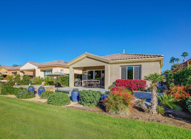 rear view of house with a yard and a patio