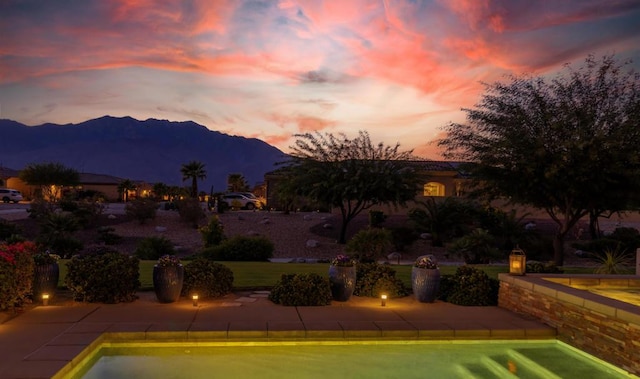 pool at dusk featuring a mountain view