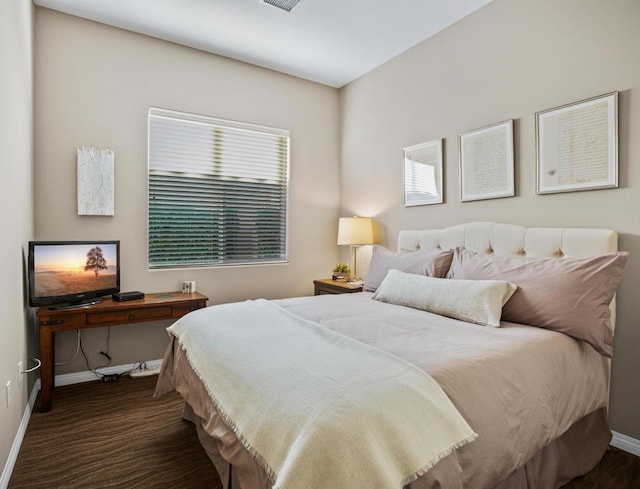 bedroom featuring dark colored carpet and multiple windows