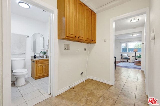 laundry room featuring electric dryer hookup, hookup for a washing machine, light tile patterned floors, and cabinets