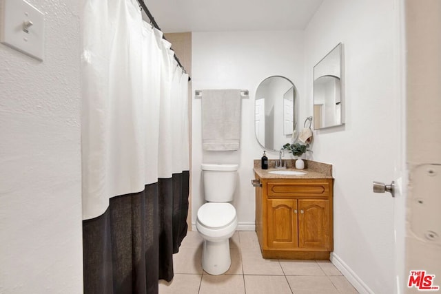 bathroom with toilet, vanity, tile patterned floors, and a shower with shower curtain