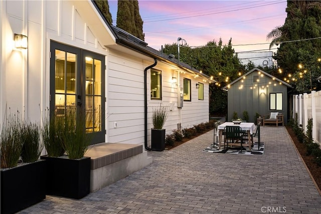 patio terrace at dusk featuring a storage shed