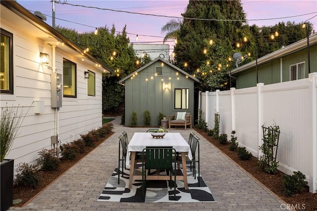 patio terrace at dusk featuring an outdoor structure