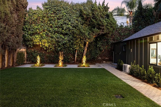 yard at dusk featuring ac unit