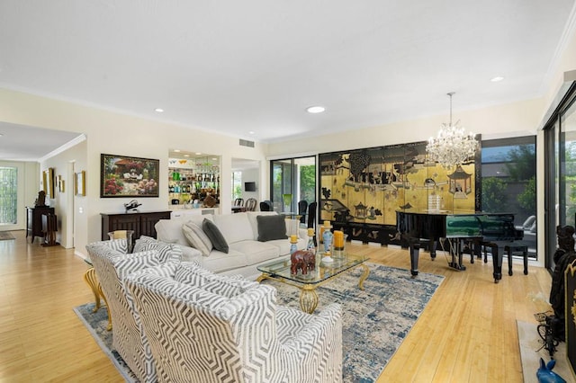 living room with a chandelier, light hardwood / wood-style flooring, and ornamental molding