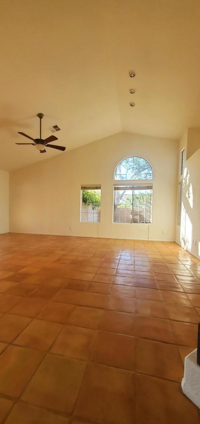 unfurnished room with ceiling fan, vaulted ceiling, and light tile patterned floors