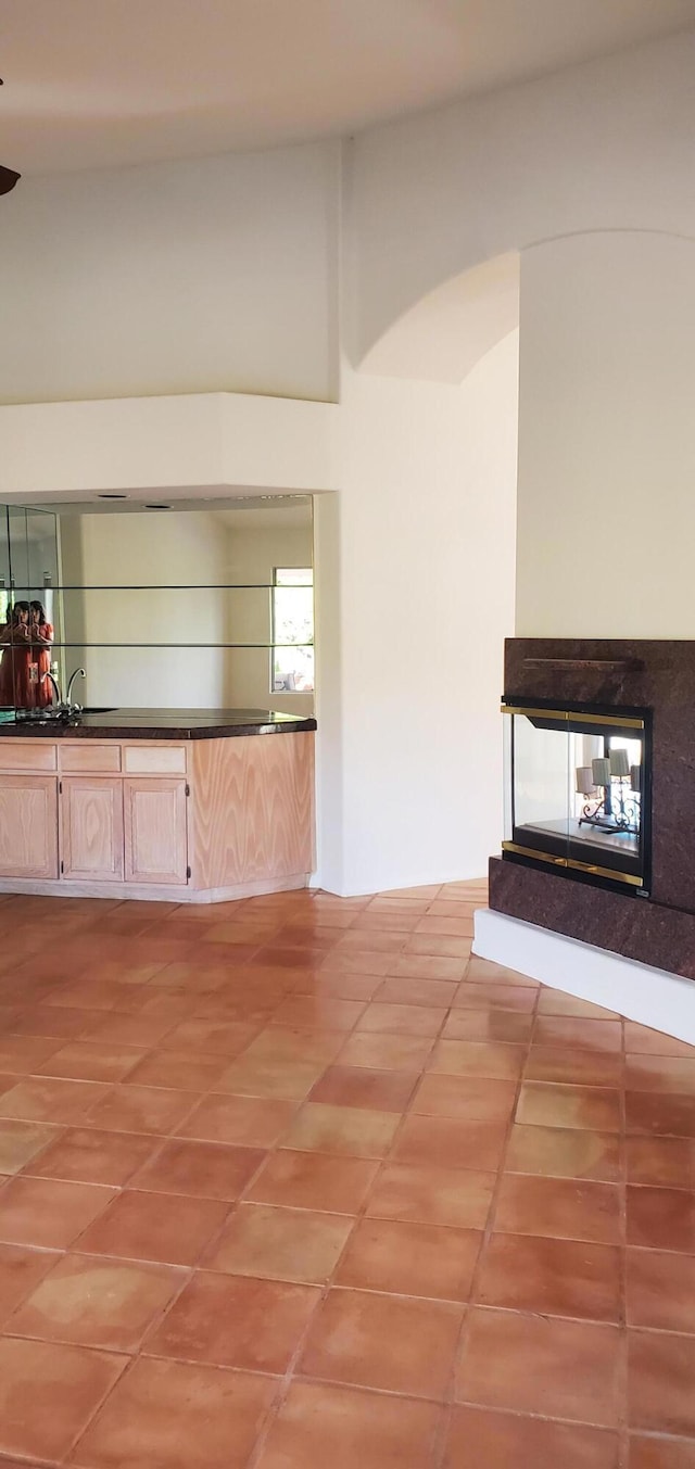 unfurnished living room featuring tile patterned floors and a high end fireplace