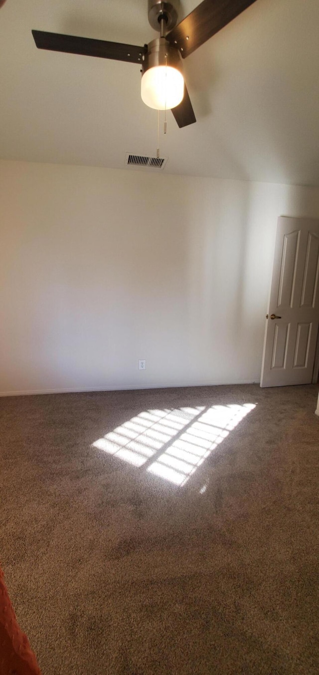 empty room featuring dark colored carpet and ceiling fan