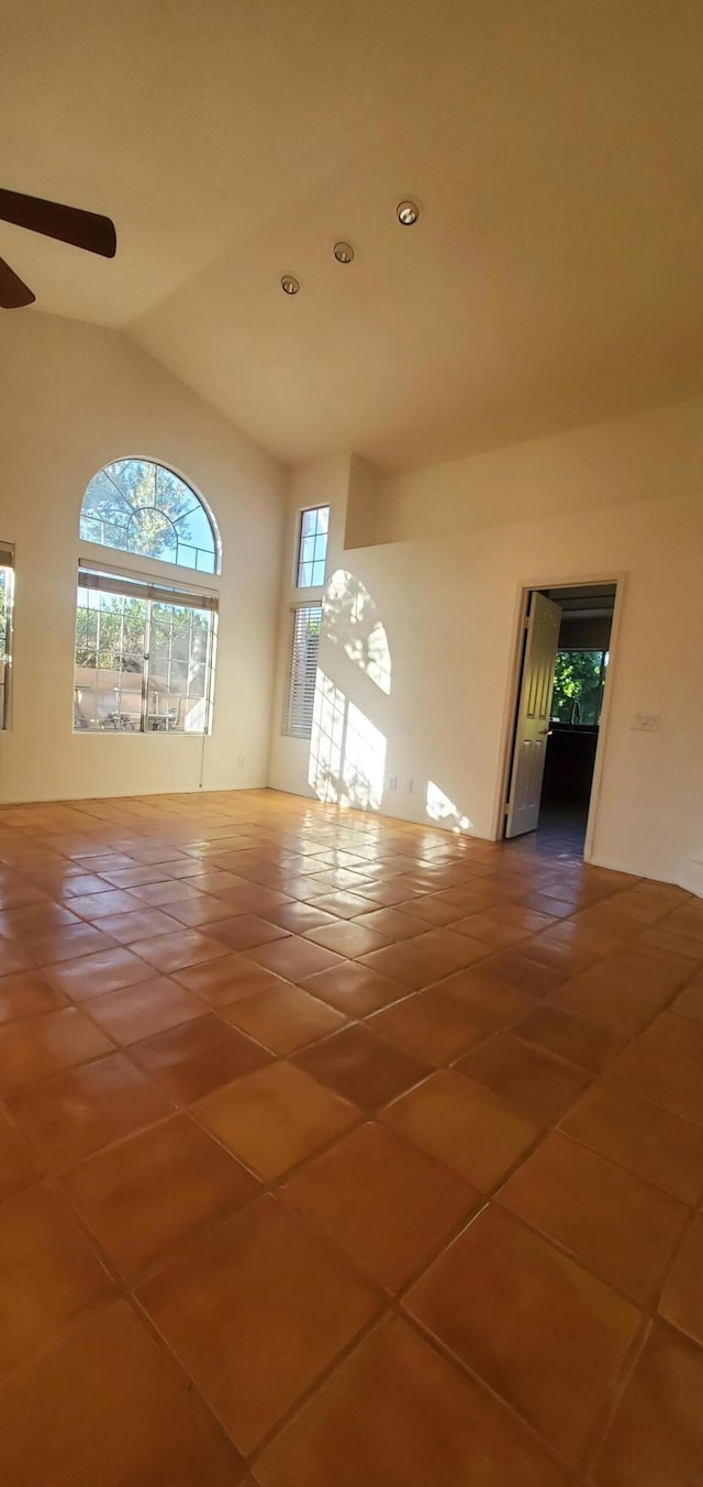 tiled spare room featuring lofted ceiling and ceiling fan