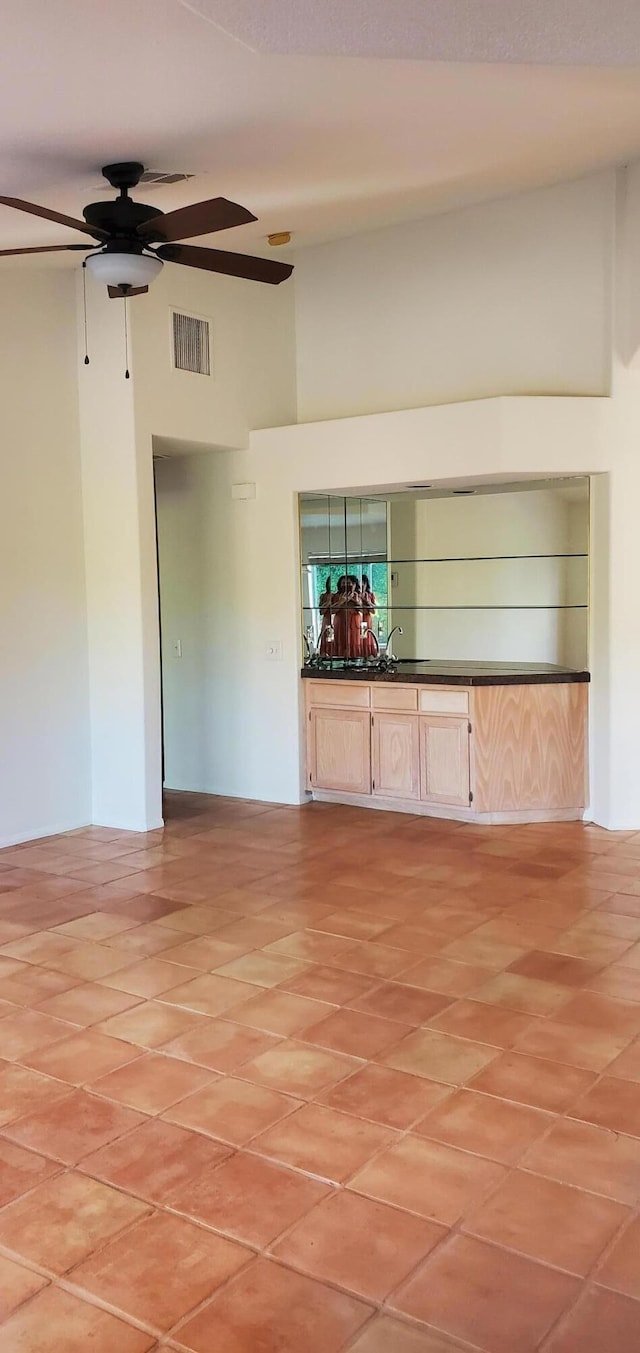 unfurnished living room featuring sink and a towering ceiling