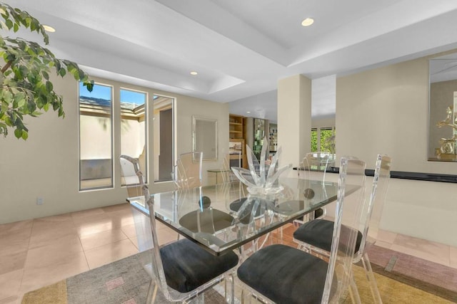 dining room with light tile patterned flooring and a tray ceiling