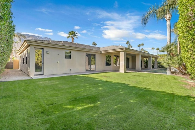 back of property featuring a patio and a yard