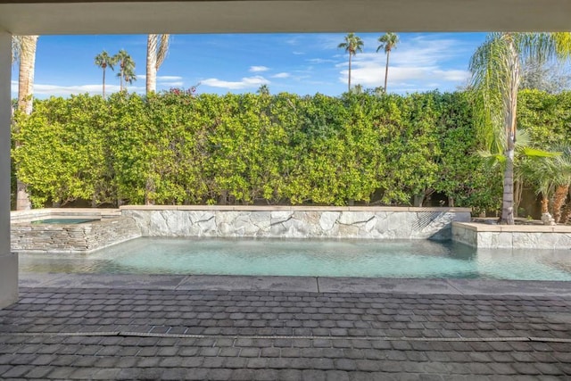 view of swimming pool featuring an in ground hot tub and pool water feature