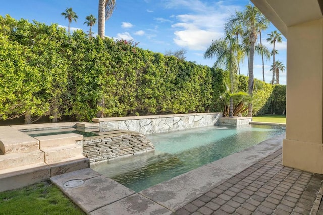 view of swimming pool featuring pool water feature and an in ground hot tub