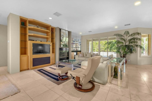 living room featuring light tile patterned floors, built in features, and plenty of natural light