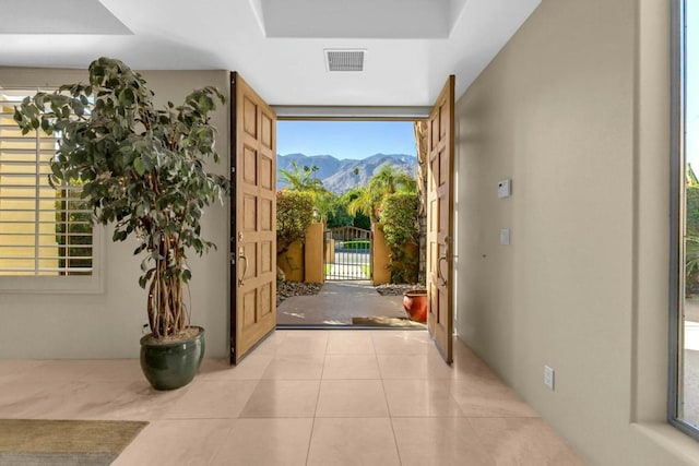 doorway to outside with a mountain view and light tile patterned flooring