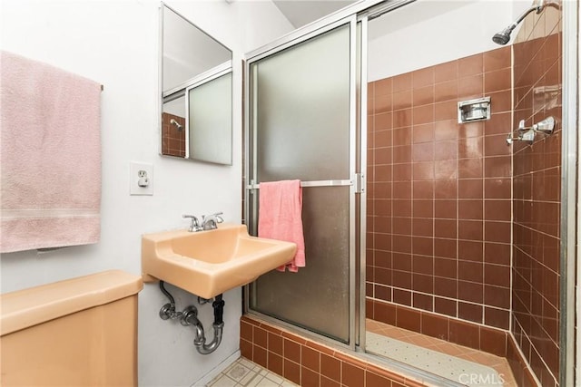 bathroom with toilet, tile patterned floors, and an enclosed shower