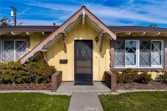 view of exterior entry with a yard