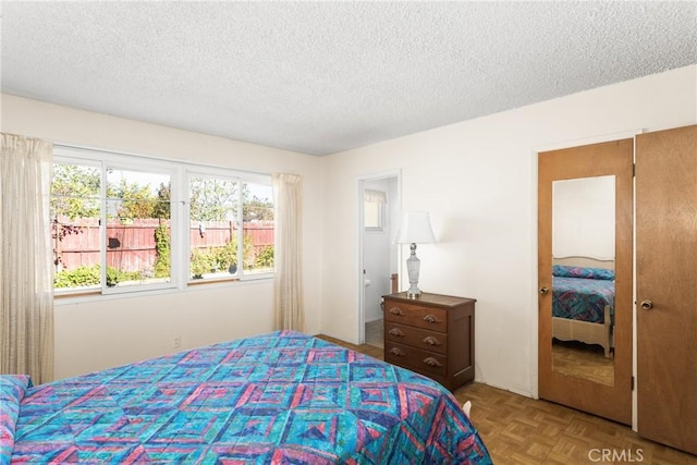 bedroom featuring light parquet floors and a textured ceiling