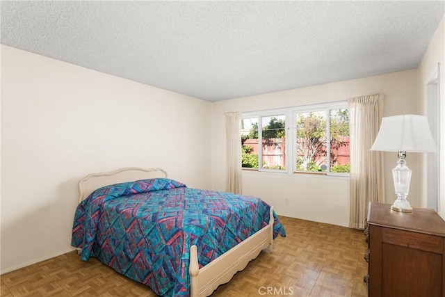 bedroom with light parquet flooring and a textured ceiling