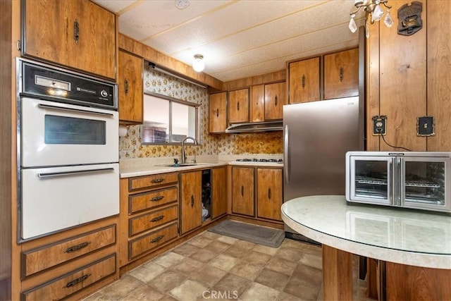 kitchen with decorative backsplash, appliances with stainless steel finishes, and sink