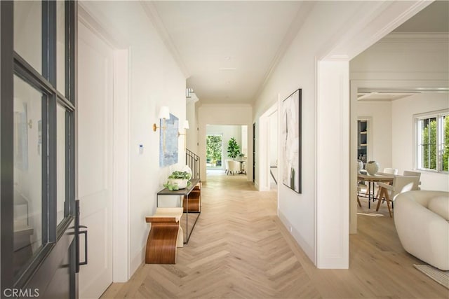 hall with crown molding and light parquet floors