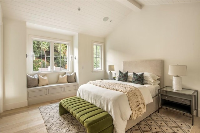 bedroom with vaulted ceiling with beams and light hardwood / wood-style floors