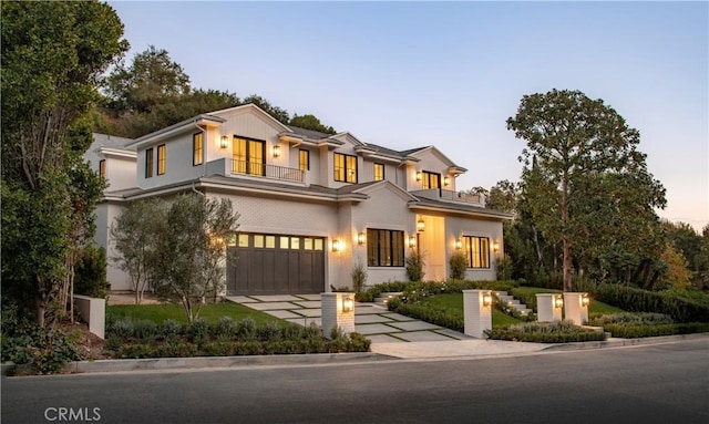 view of front of property featuring a balcony and a garage