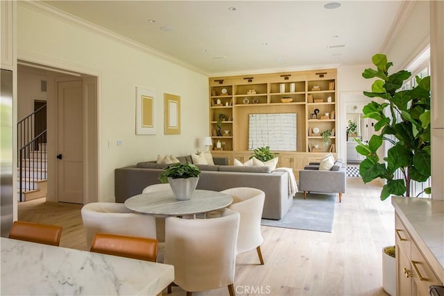 dining space with crown molding and light hardwood / wood-style floors