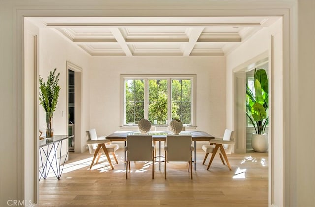 dining area with beamed ceiling, light hardwood / wood-style floors, coffered ceiling, and ornamental molding