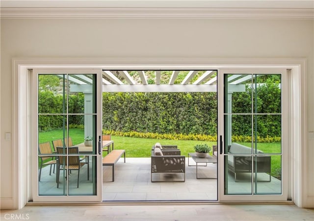 entryway with hardwood / wood-style floors, ornamental molding, and a wealth of natural light