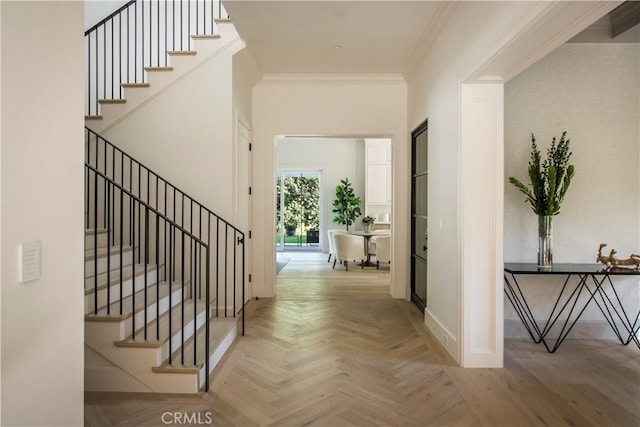 entryway with parquet flooring and ornamental molding