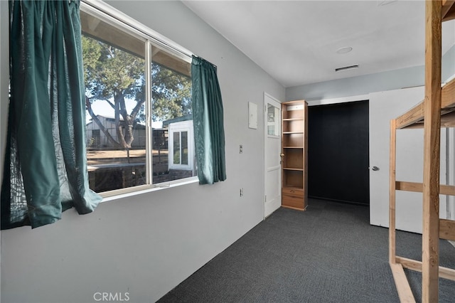 hallway featuring dark colored carpet