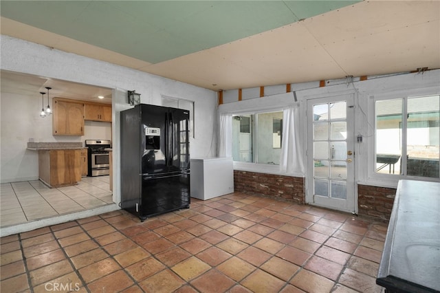 interior space featuring light tile patterned flooring, black fridge with ice dispenser, and stainless steel range oven