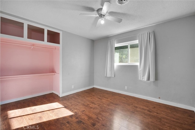 spare room with ceiling fan, dark wood-type flooring, and a textured ceiling