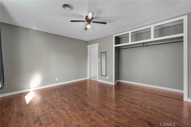 unfurnished bedroom featuring ceiling fan, a closet, a textured ceiling, and hardwood / wood-style flooring