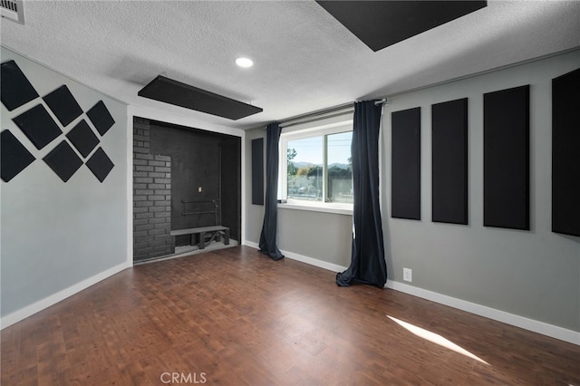 interior space featuring a textured ceiling and dark wood-type flooring