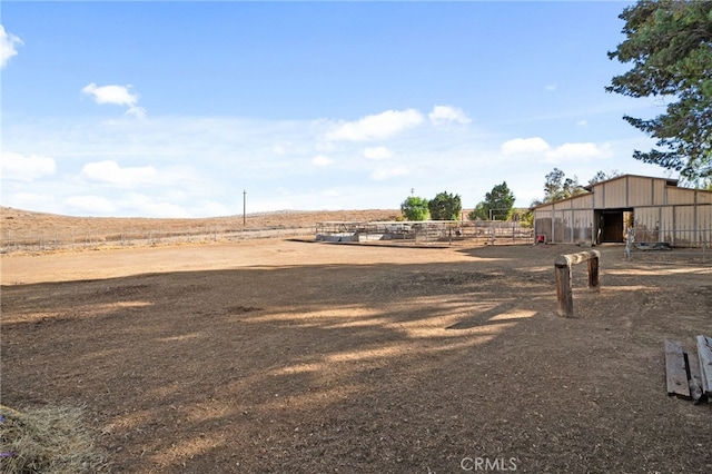 view of yard featuring a rural view and an outbuilding