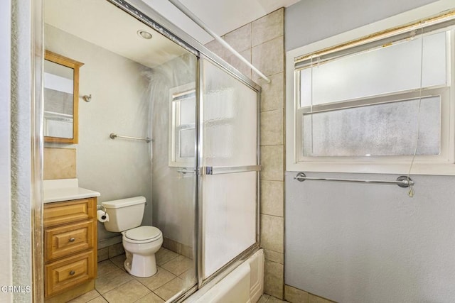 full bathroom with combined bath / shower with glass door, vanity, tile patterned floors, and toilet