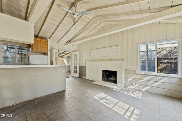 unfurnished living room with ceiling fan, wood ceiling, and vaulted ceiling with beams