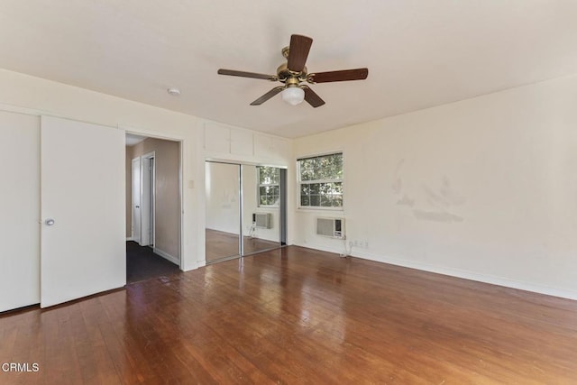 unfurnished room featuring ceiling fan, dark hardwood / wood-style flooring, and a wall mounted air conditioner