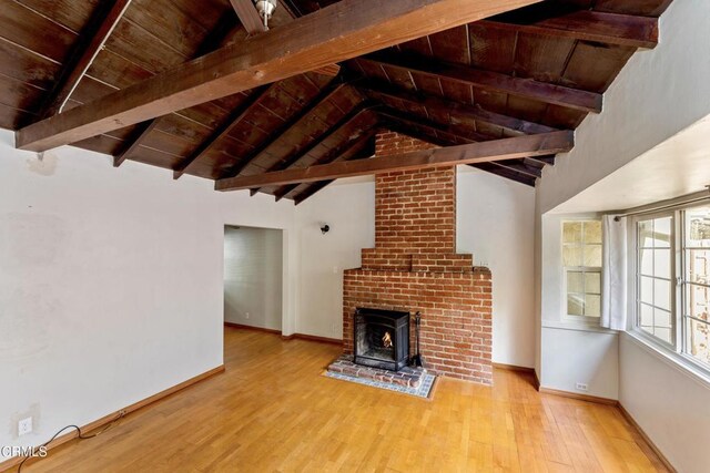 unfurnished living room with light hardwood / wood-style floors, lofted ceiling with beams, and wood ceiling