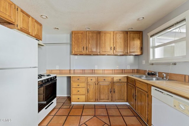 kitchen featuring tile patterned flooring, sink, and white appliances