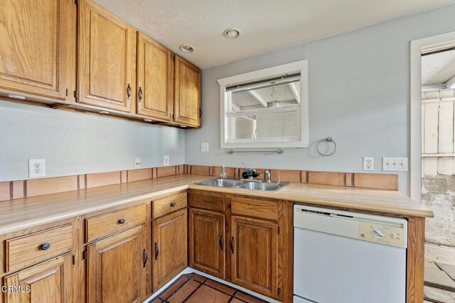 kitchen with sink, light tile patterned floors, dishwasher, and plenty of natural light