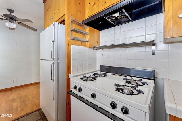 kitchen with decorative backsplash, white appliances, ceiling fan, and tile patterned flooring