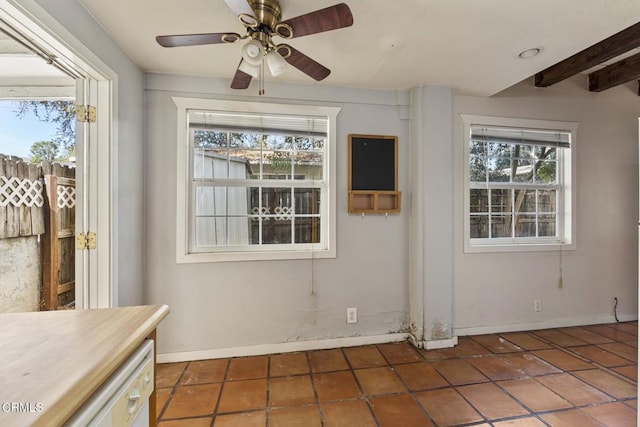 unfurnished dining area with ceiling fan, tile patterned floors, and beamed ceiling