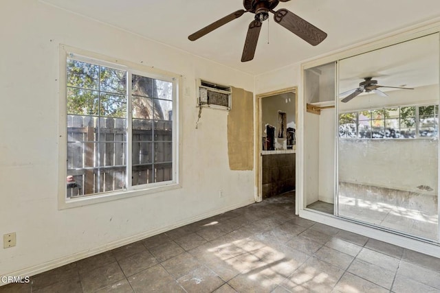 empty room featuring ceiling fan, plenty of natural light, and an AC wall unit