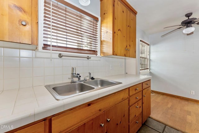 kitchen featuring tile counters, backsplash, plenty of natural light, and sink