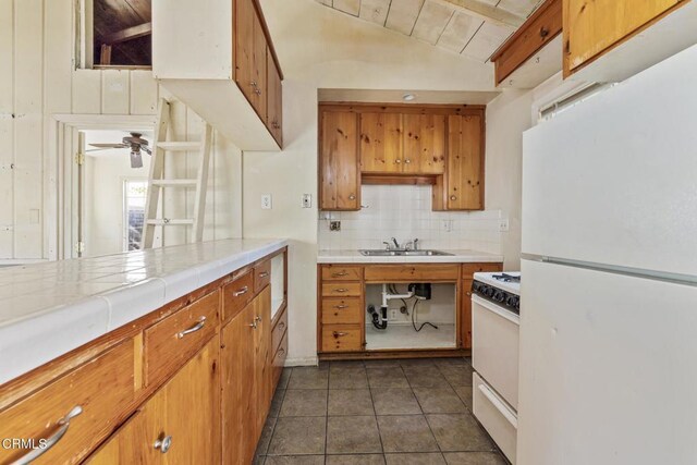 kitchen with white appliances, lofted ceiling with beams, tile countertops, ceiling fan, and wooden ceiling